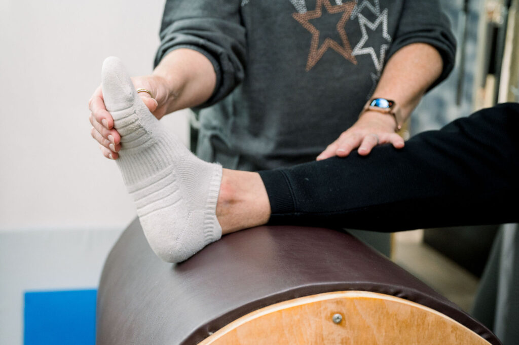 Close up a clients foot on the ladder barrel during a private pilates session